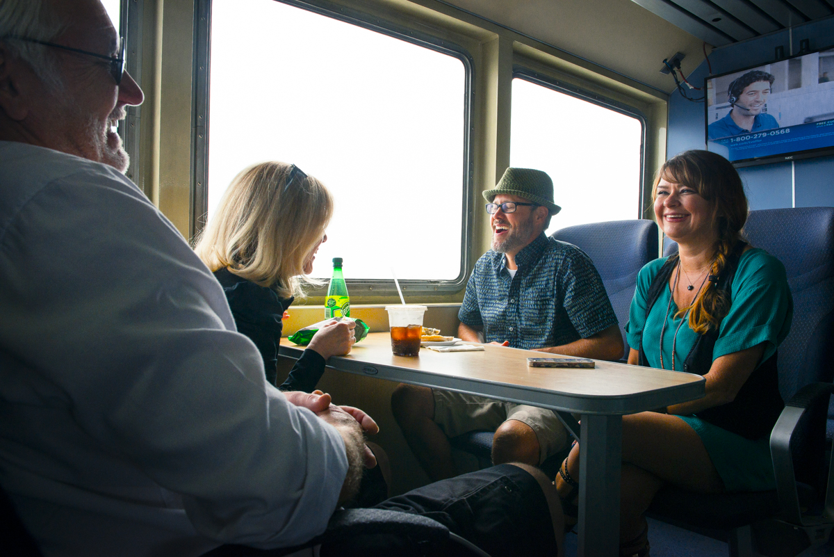 Friends enjoy the ride as they eat snacks around a table on the ferry