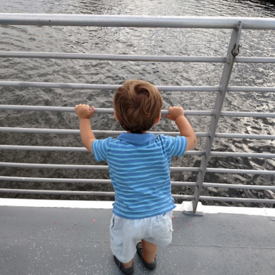 Young child looking out over the water from the ferry