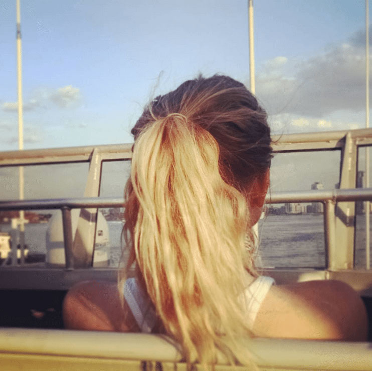 Woman looking out on the city from the top deck of the Seastreak Ferry