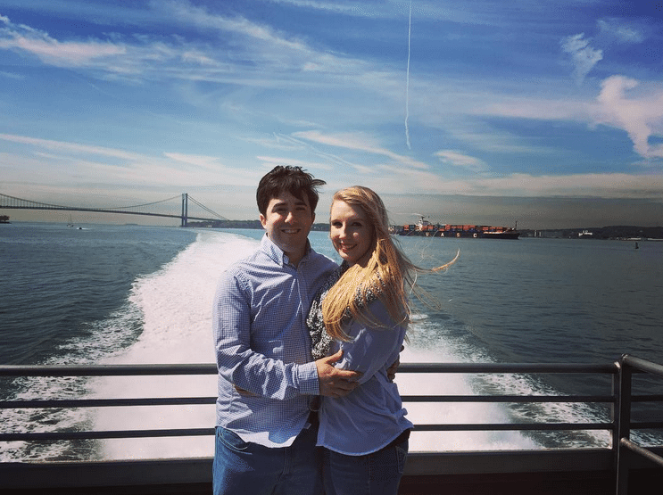 Couple on the stern of the ferry with the wake behind them