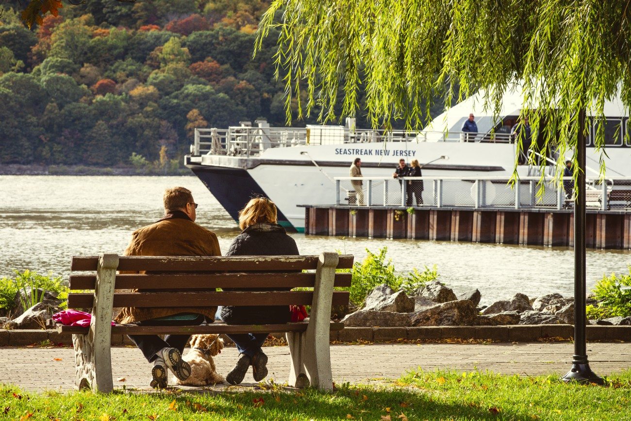 Couple sitting on a bench looking at the ferry