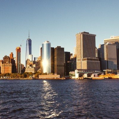 The sun glinting off the skyscrapers of lower Manhattan while viewed from the deck of a Seastreak Ferry
