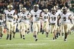 Football players running on to the field at West Point.